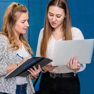 Zwei Studentinnen unterhalten sich auf dem Weg zur Vorlesung