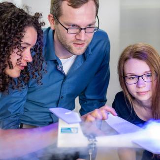 Zwei Studentinnen und ein Professor beobachten den Strömungskanal